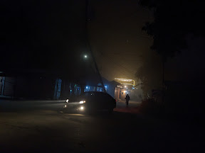 Car headlights in a foggy night on a dark street shot by miqdad23.